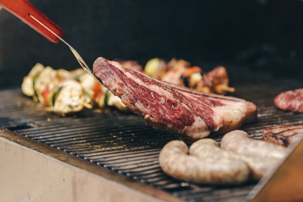 Corte de carne sellándose sobre la brasa